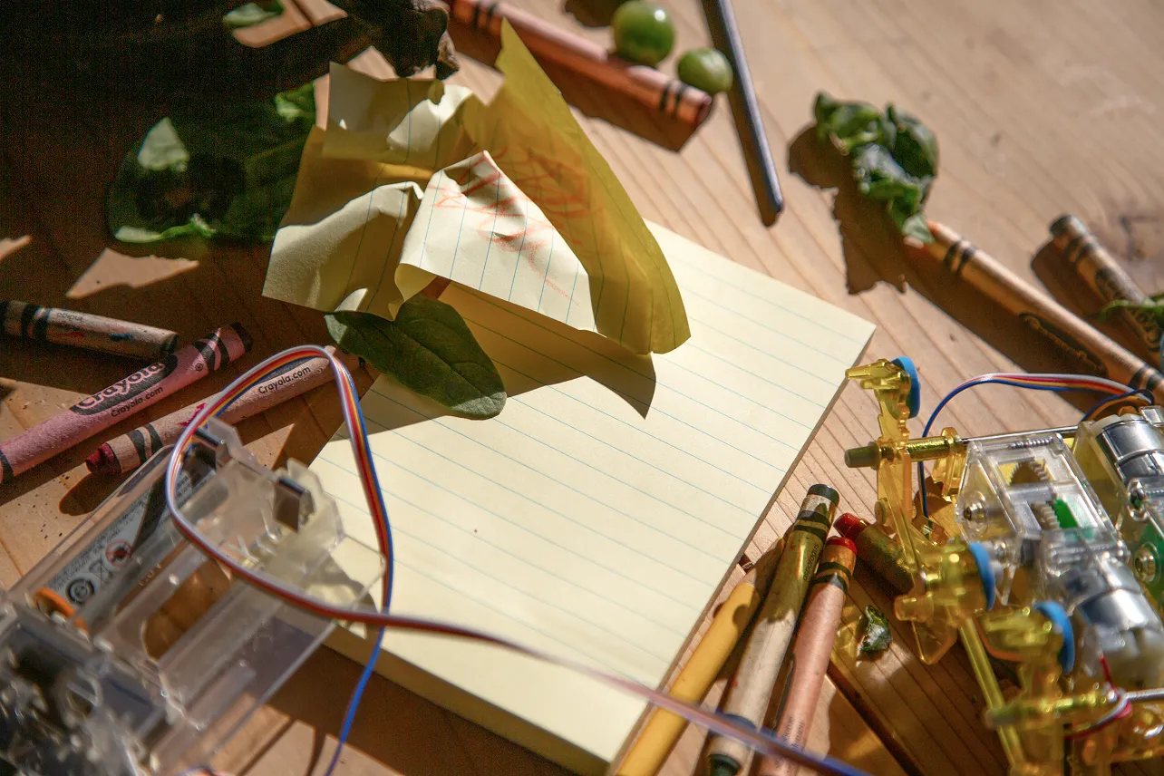 In progress electronic, crayons and a writing pad